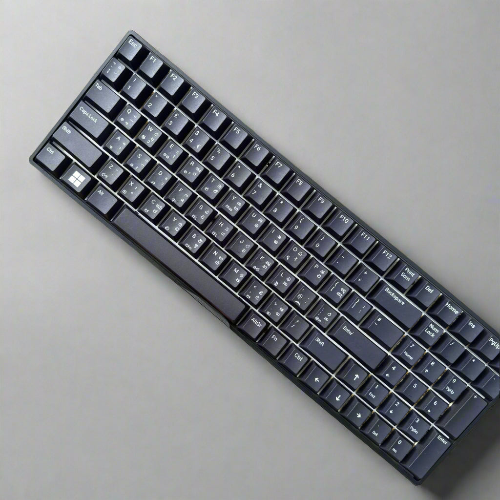 Black keyboard held by a hand against a stone wall background