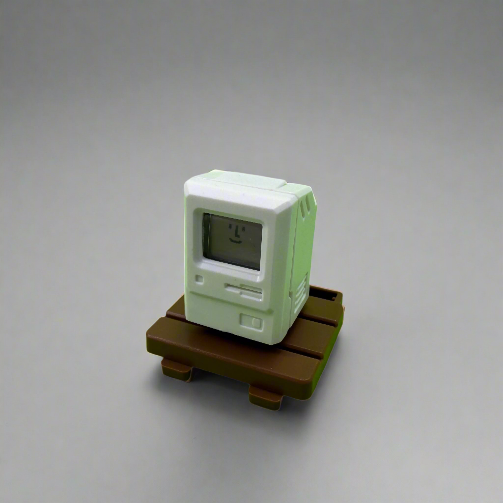 An artisan keycap designed to look like a mini vintage monitor with a built-in light-up screen, featuring pixel-style elements and soft retro tones.